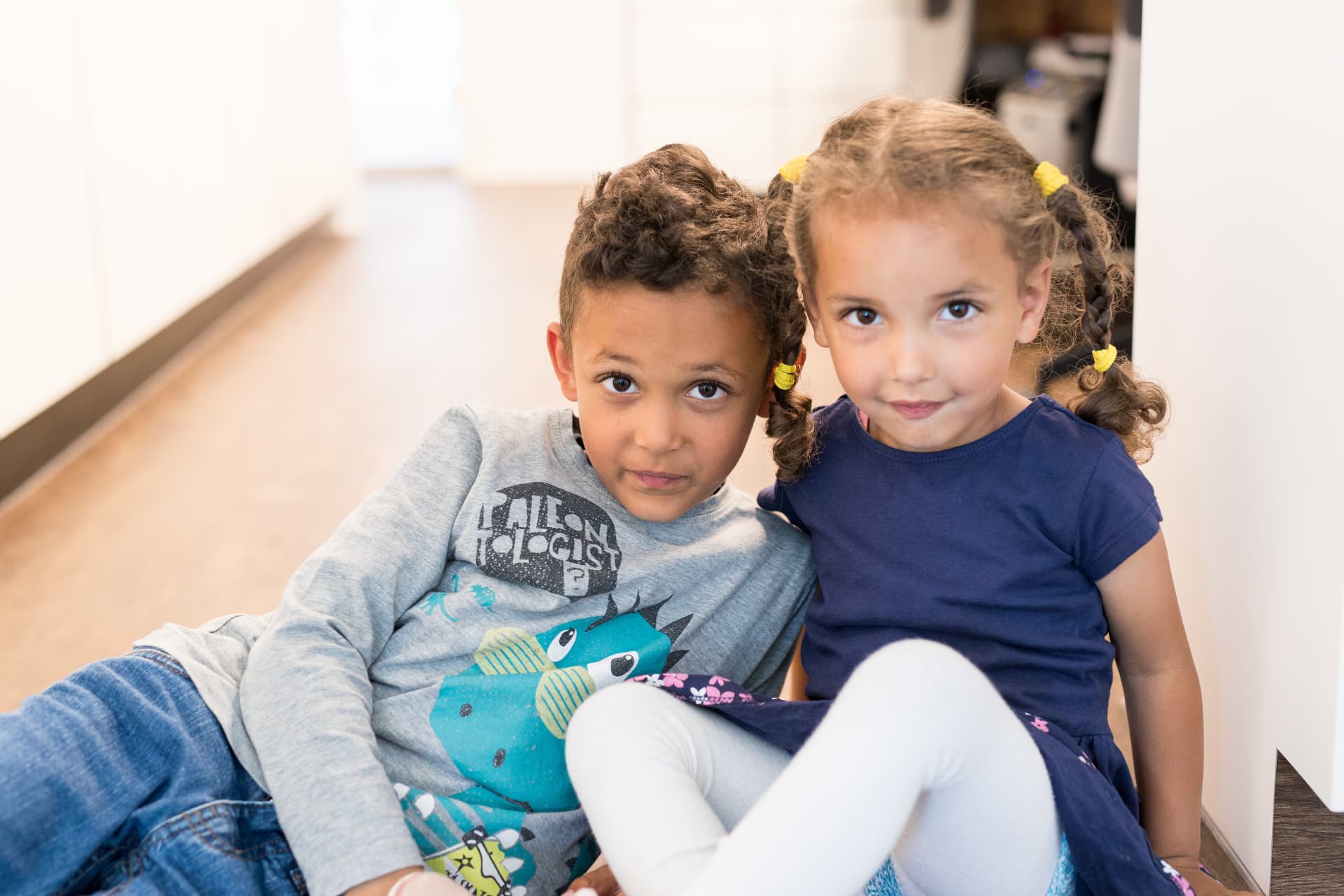 Zwei Kinder im freundlichen Flur des Dentino Clubs